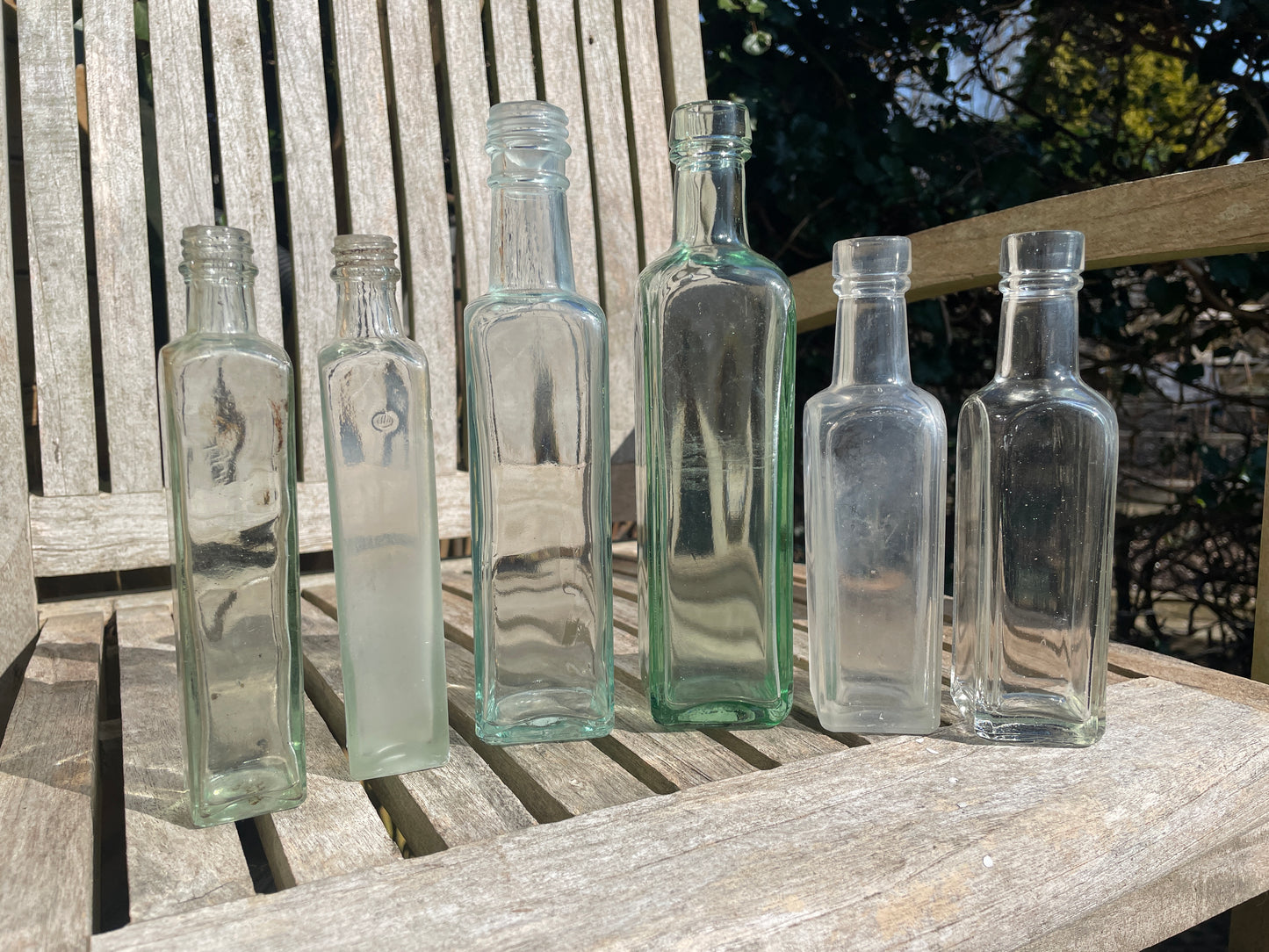 Six antique and vintage clear glass square section bottles tallest 21.5cm