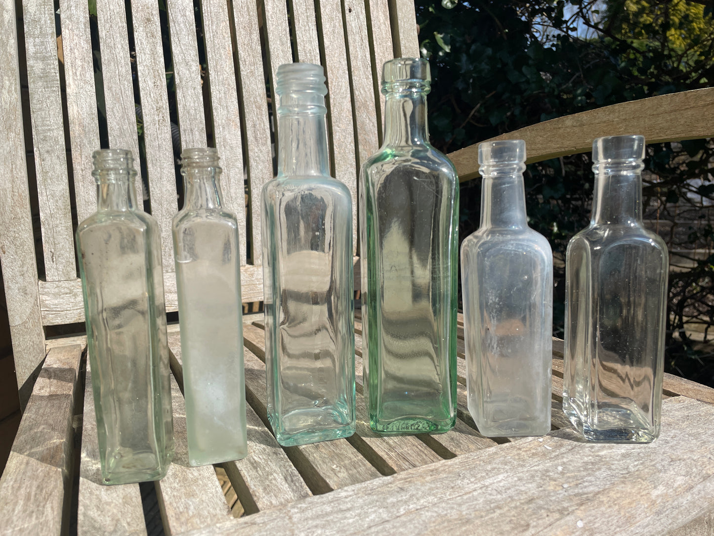 Six antique and vintage clear glass square section bottles tallest 21.5cm