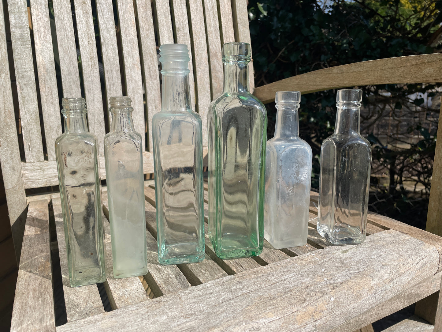 Six antique and vintage clear glass square section bottles tallest 21.5cm