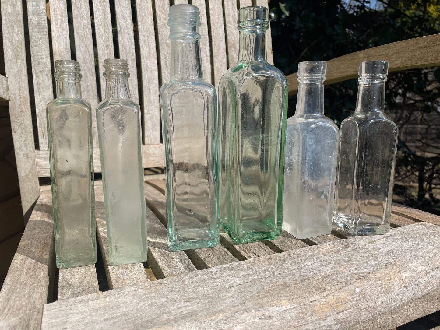 Six antique and vintage clear glass square section bottles tallest 21.5cm