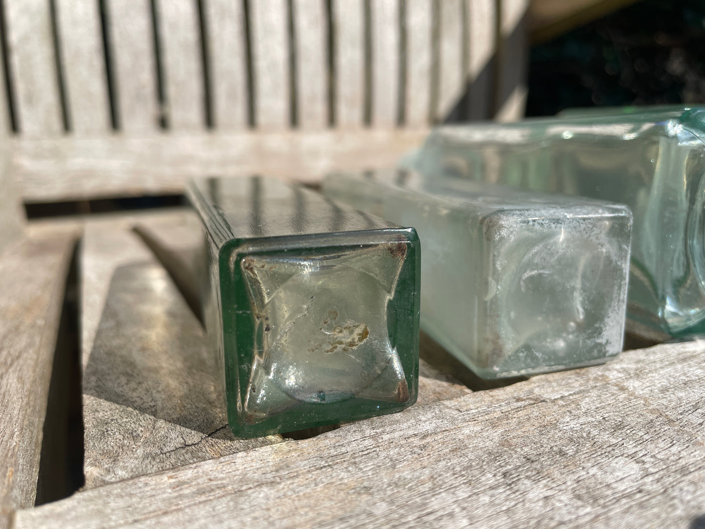 Six antique and vintage clear glass square section bottles tallest 21.5cm
