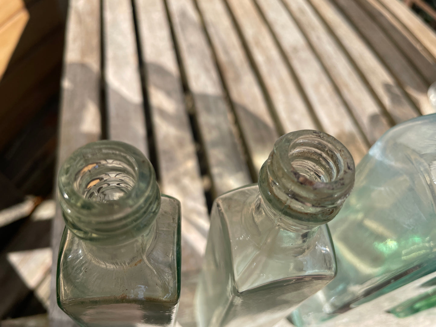 Six antique and vintage clear glass square section bottles tallest 21.5cm