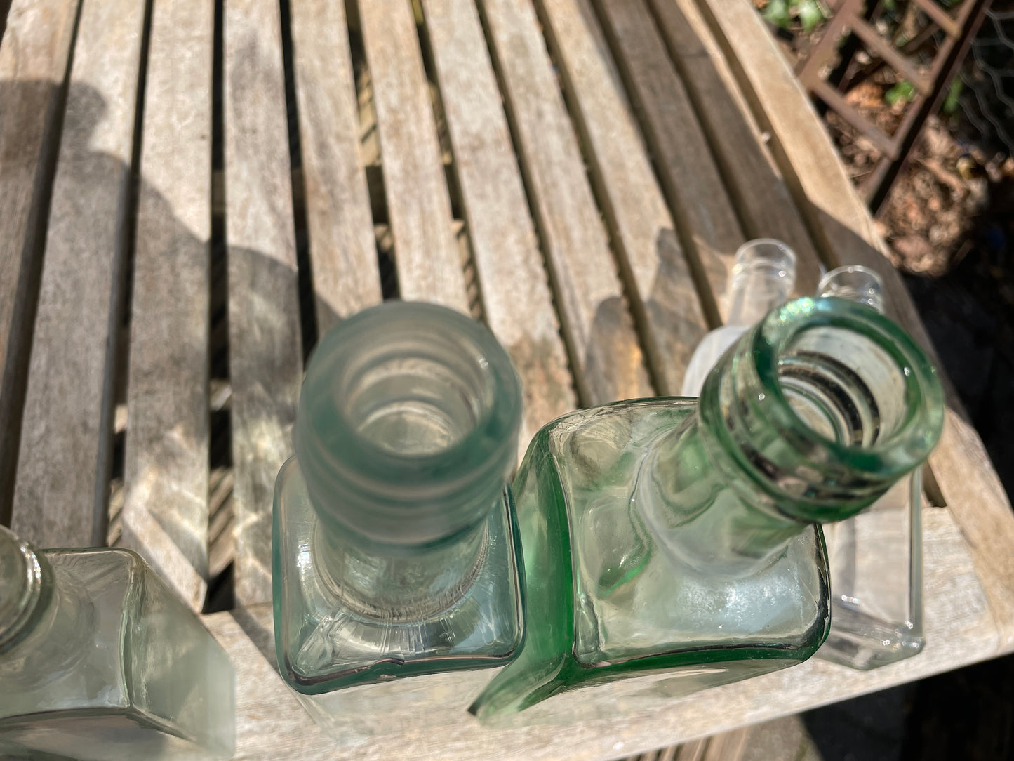 Six antique and vintage clear glass square section bottles tallest 21.5cm