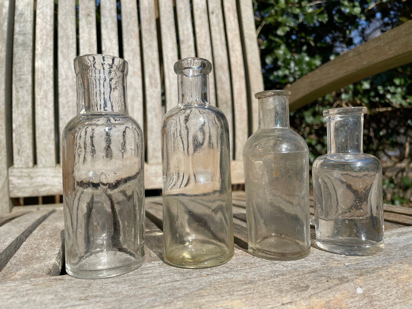 Four clear old glass medicine bottles tallest 11.5cm