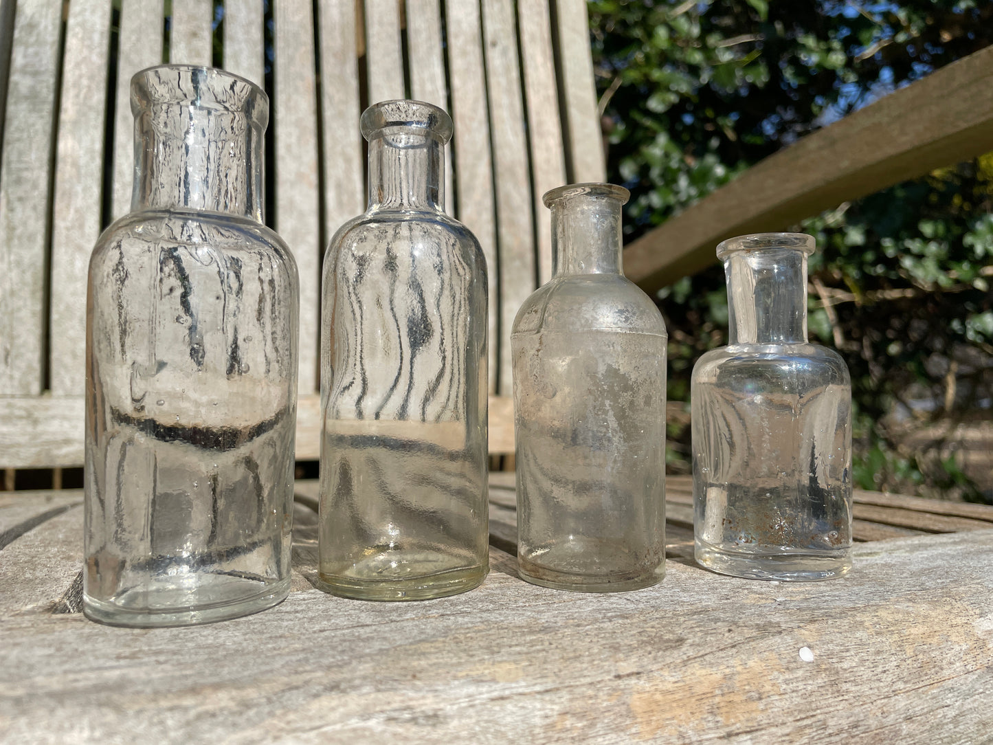 Four clear old glass medicine bottles tallest 11.5cm