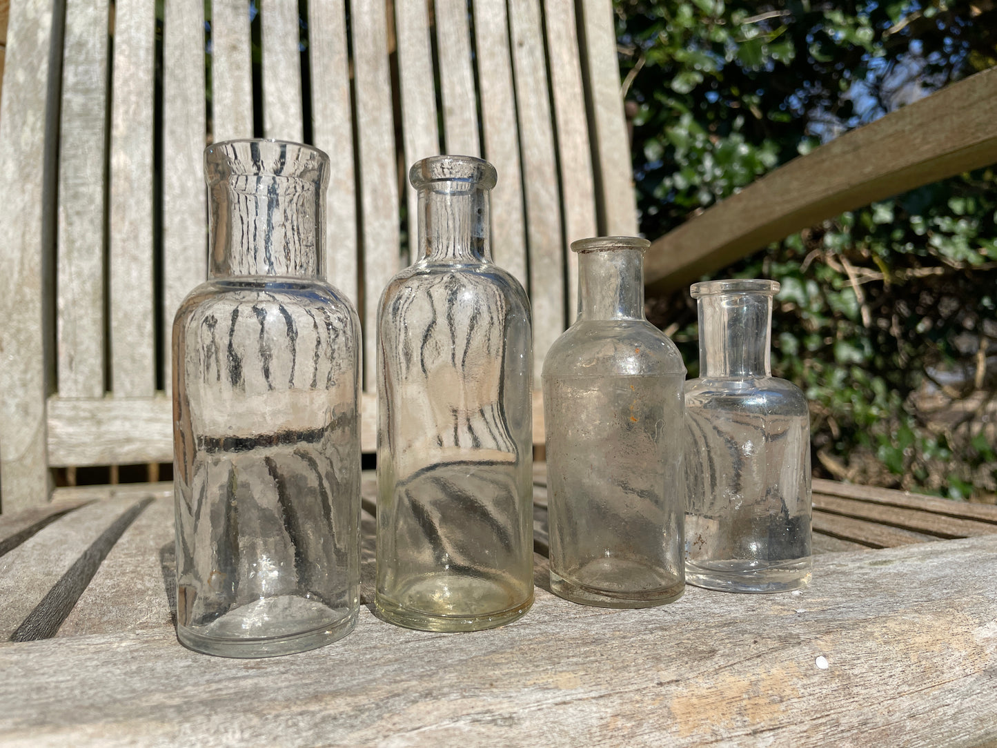 Four clear old glass medicine bottles tallest 11.5cm