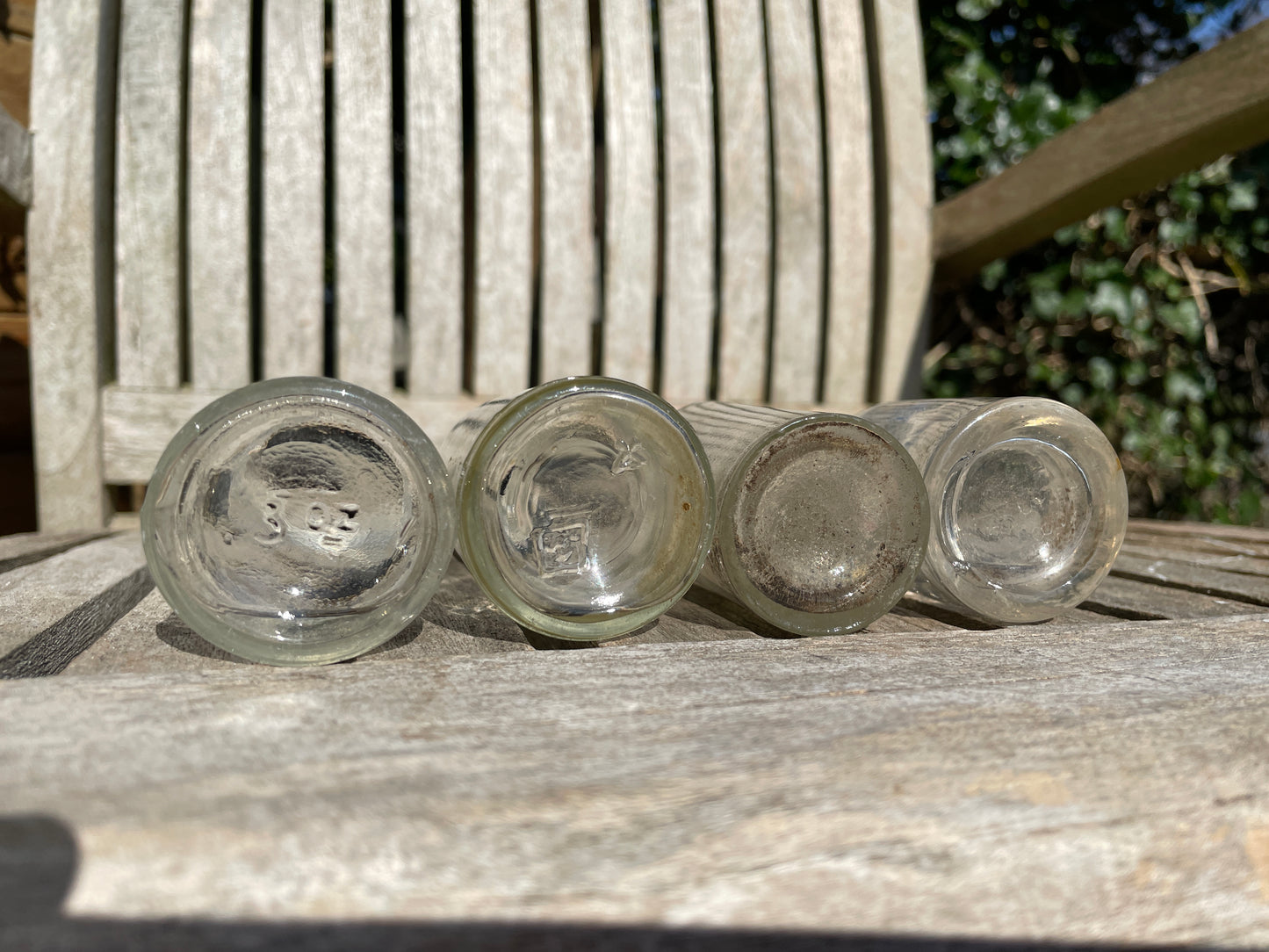 Four clear old glass medicine bottles tallest 11.5cm