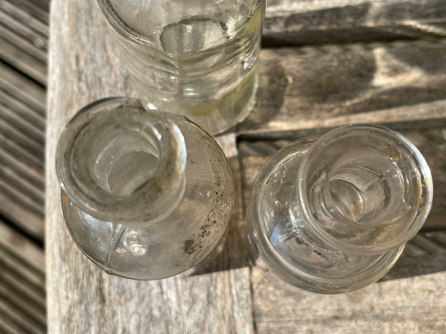 Four clear old glass medicine bottles tallest 11.5cm
