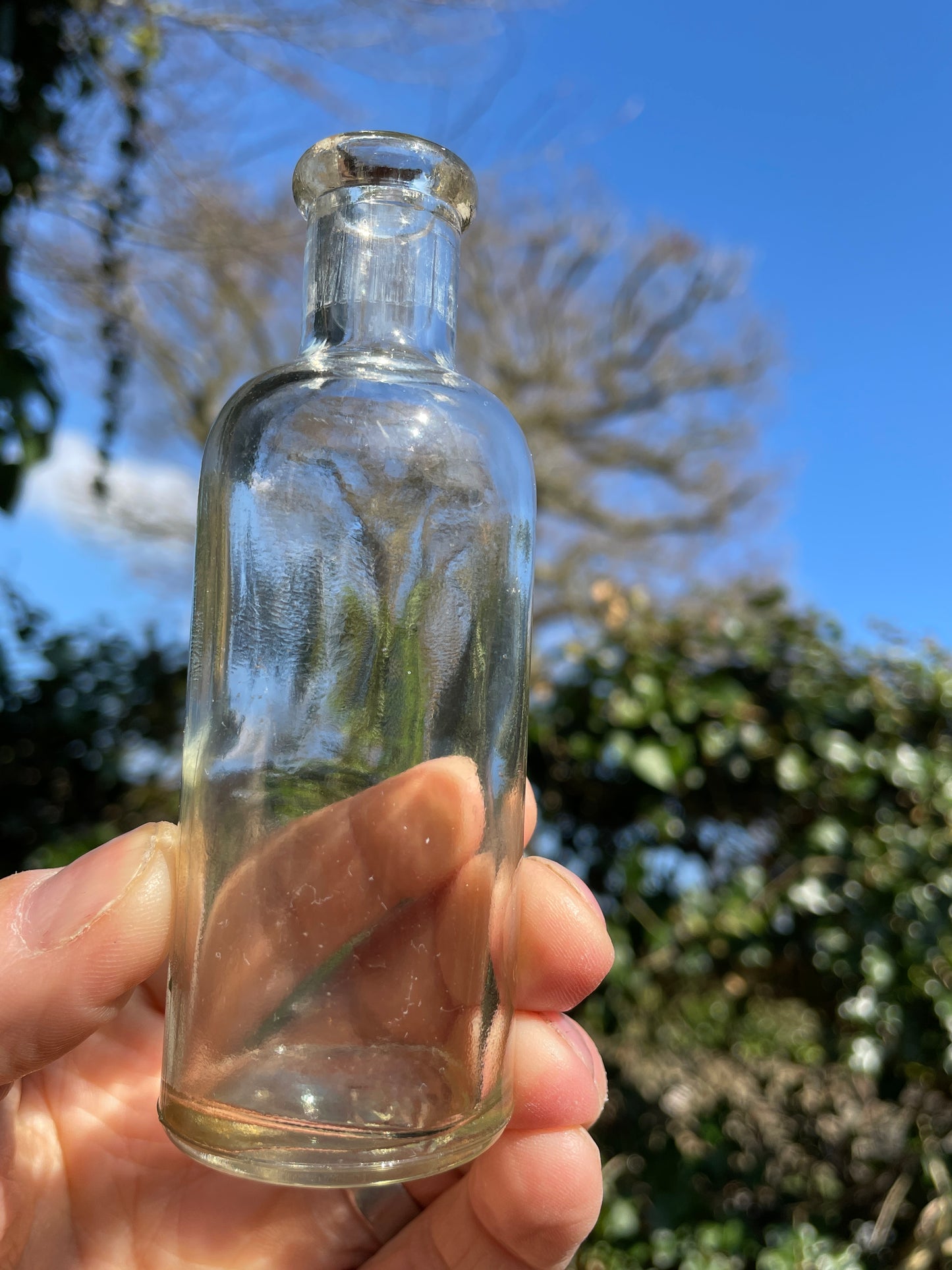 Four clear old glass medicine bottles tallest 11.5cm