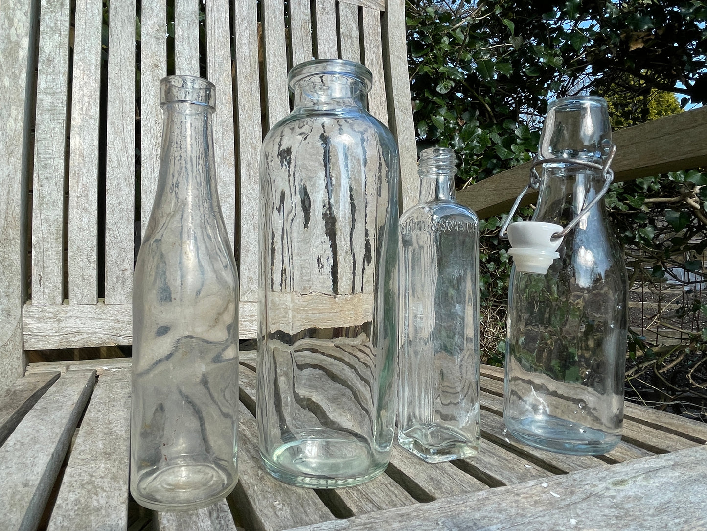Four vintage clear glass bottles Tallest 19cm