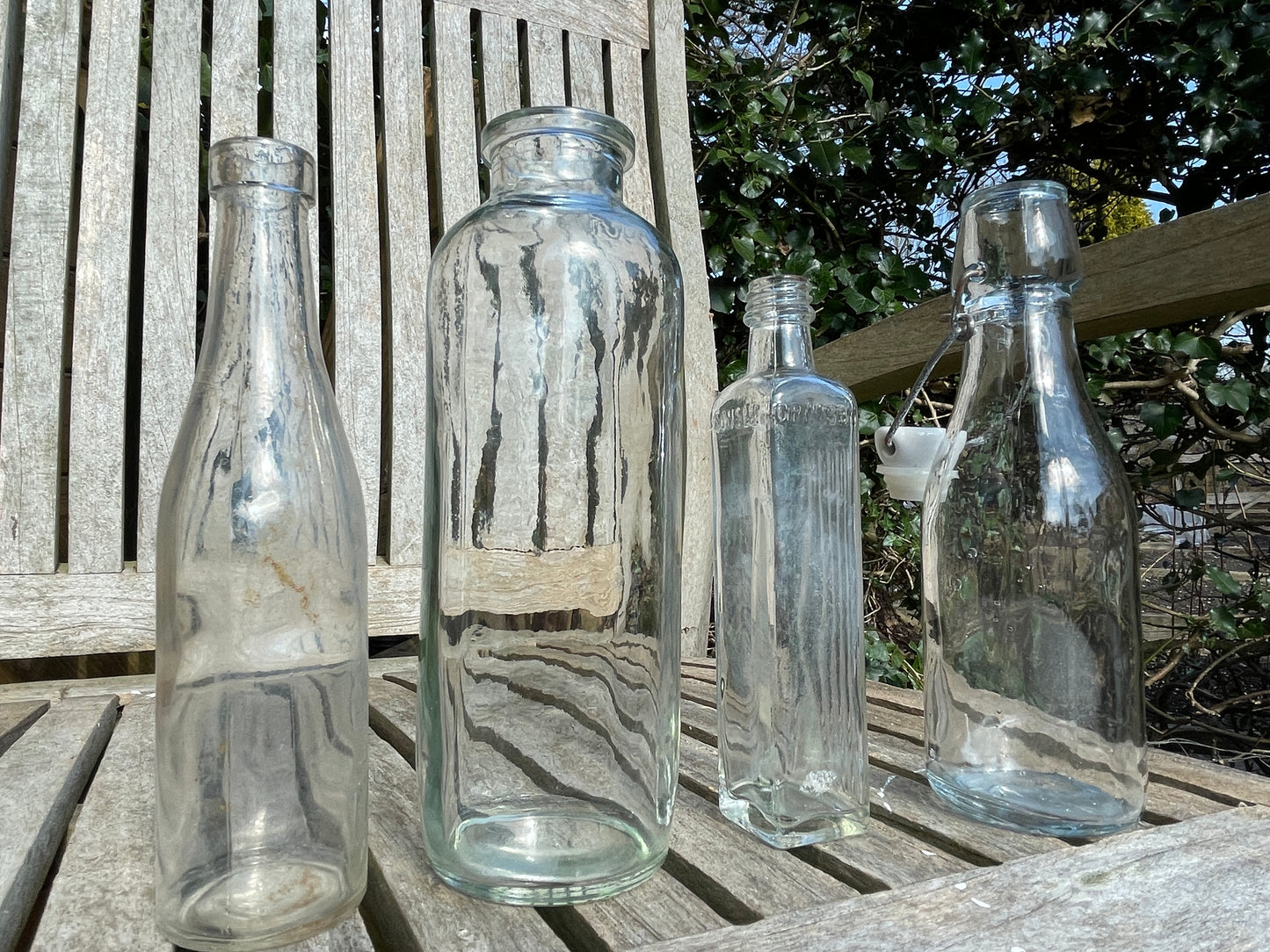 Four vintage clear glass bottles Tallest 19cm