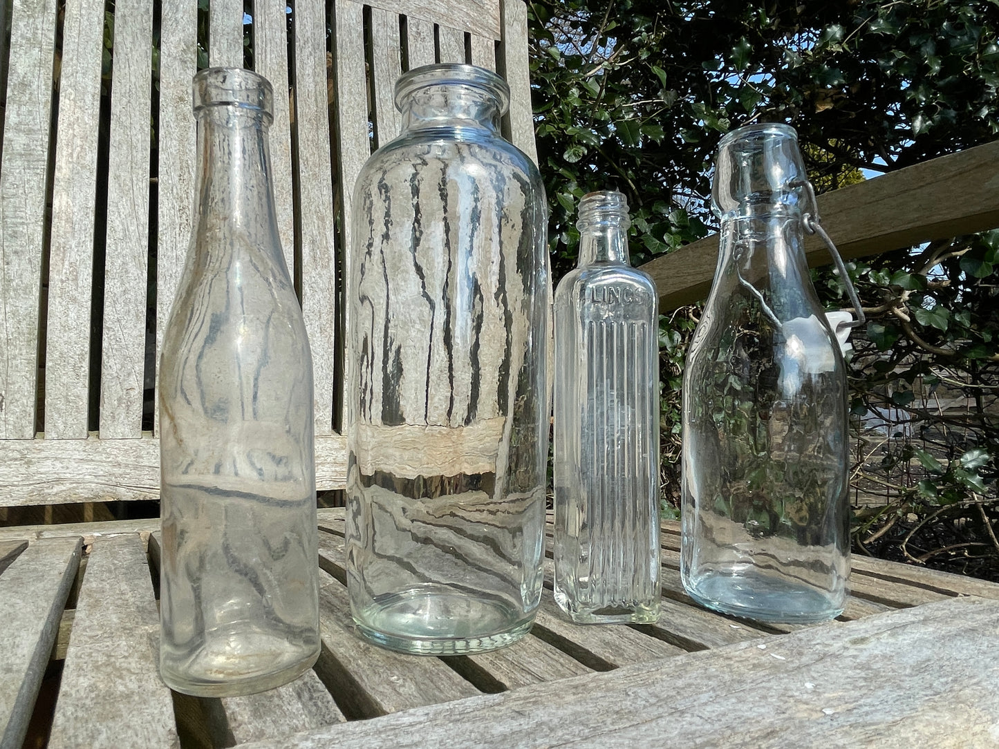 Four vintage clear glass bottles Tallest 19cm