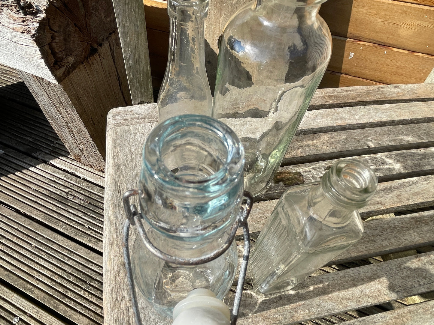 Four vintage clear glass bottles Tallest 19cm