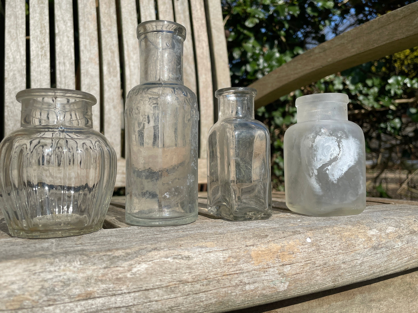 Four clear glass vintage bottles tallest 13.5cm one marked Furniture cream Stephenson Brothers