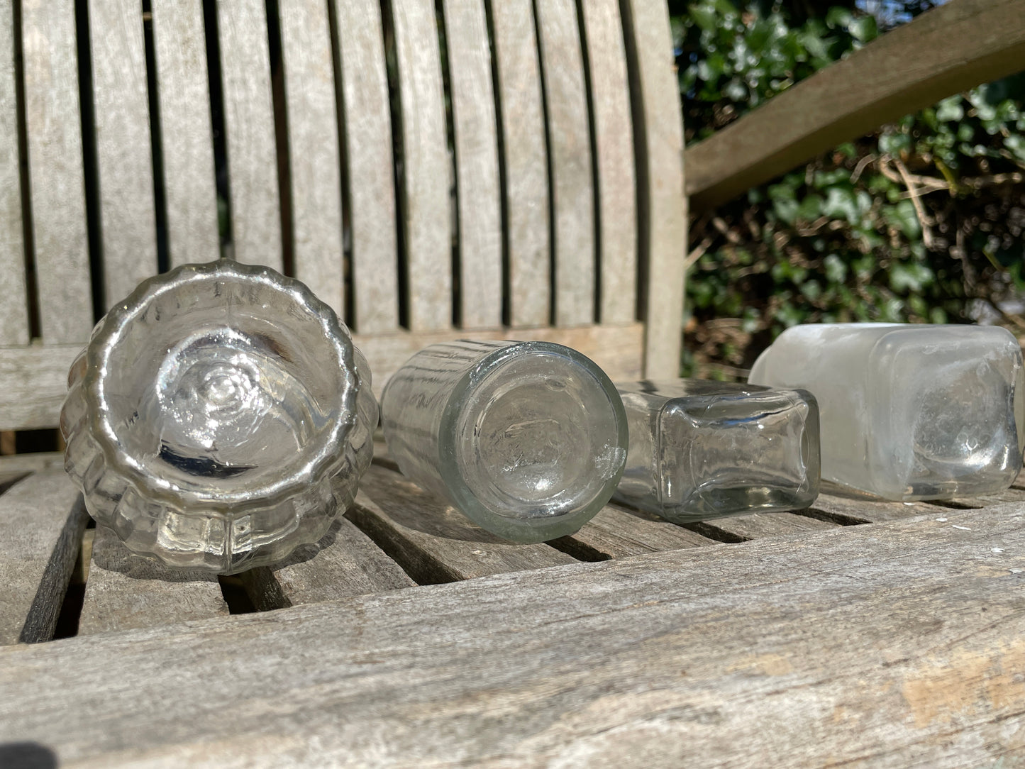 Four clear glass vintage bottles tallest 13.5cm one marked Furniture cream Stephenson Brothers