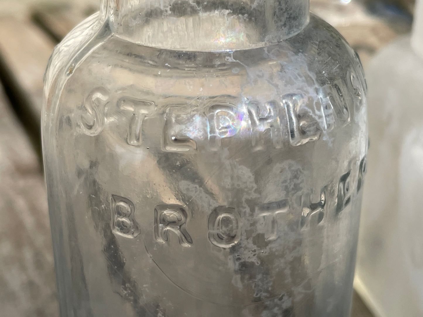 Four clear glass vintage bottles tallest 13.5cm one marked Furniture cream Stephenson Brothers