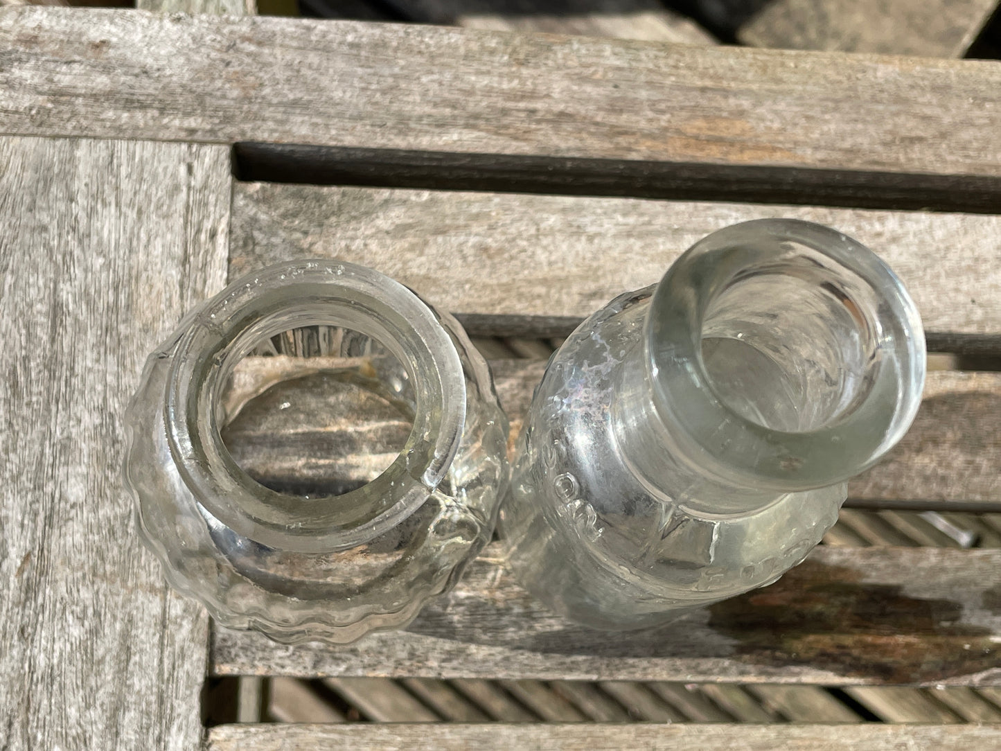 Four clear glass vintage bottles tallest 13.5cm one marked Furniture cream Stephenson Brothers