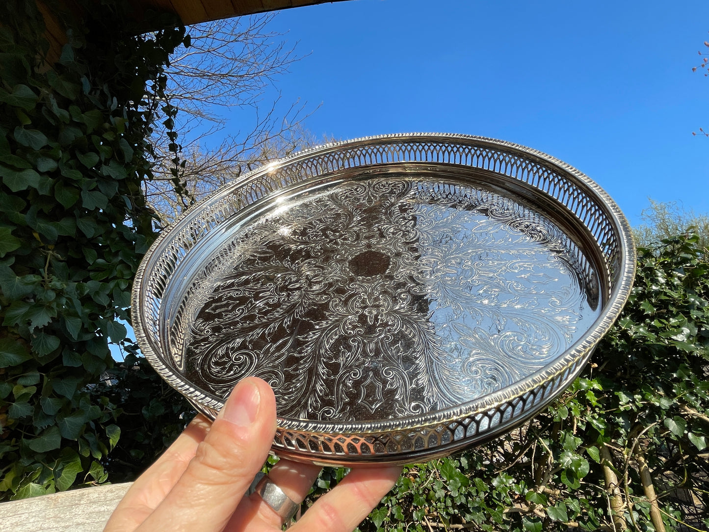 Early 20th century English silver plated galleried and ornately chased tray on three bun feet