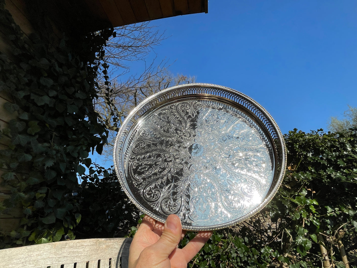 Early 20th century English silver plated galleried and ornately chased tray on three bun feet