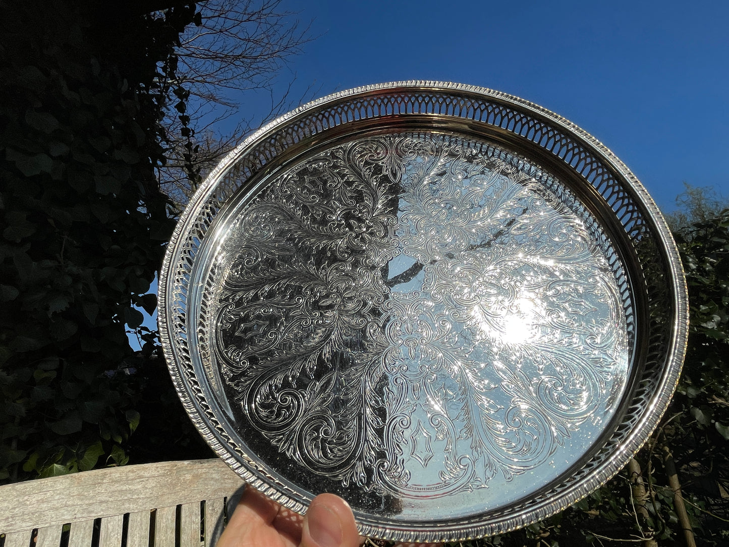 Early 20th century English silver plated galleried and ornately chased tray on three bun feet