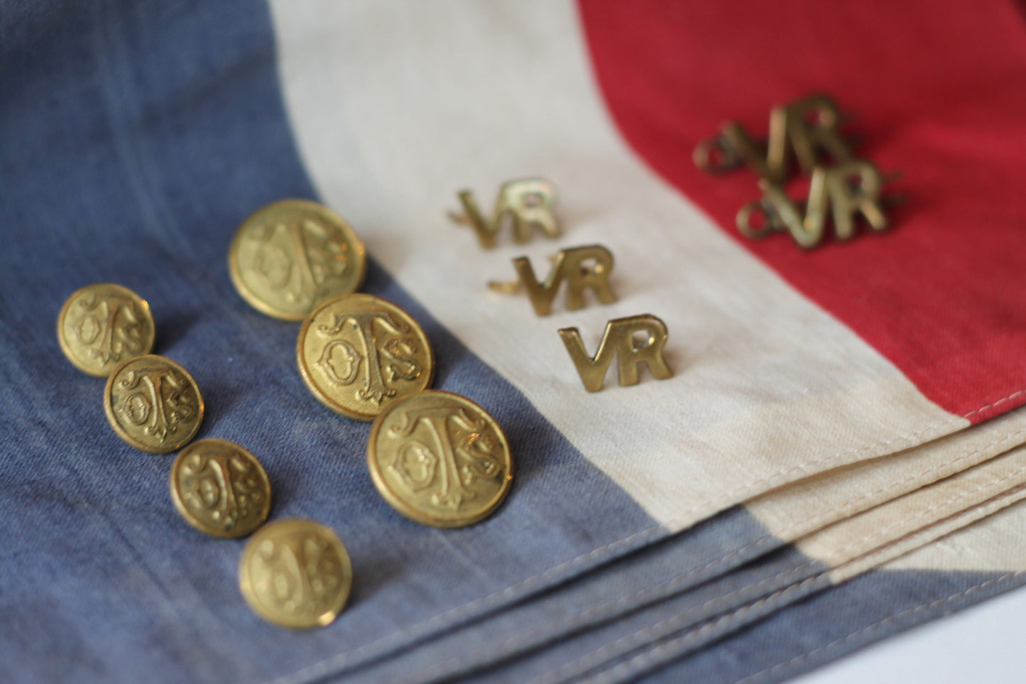 Five Volunteer Reserves Brass 'VR's' Title badges and Seven oTs Officer Training School Gilt Uniform Buttons by Firmin & Sons