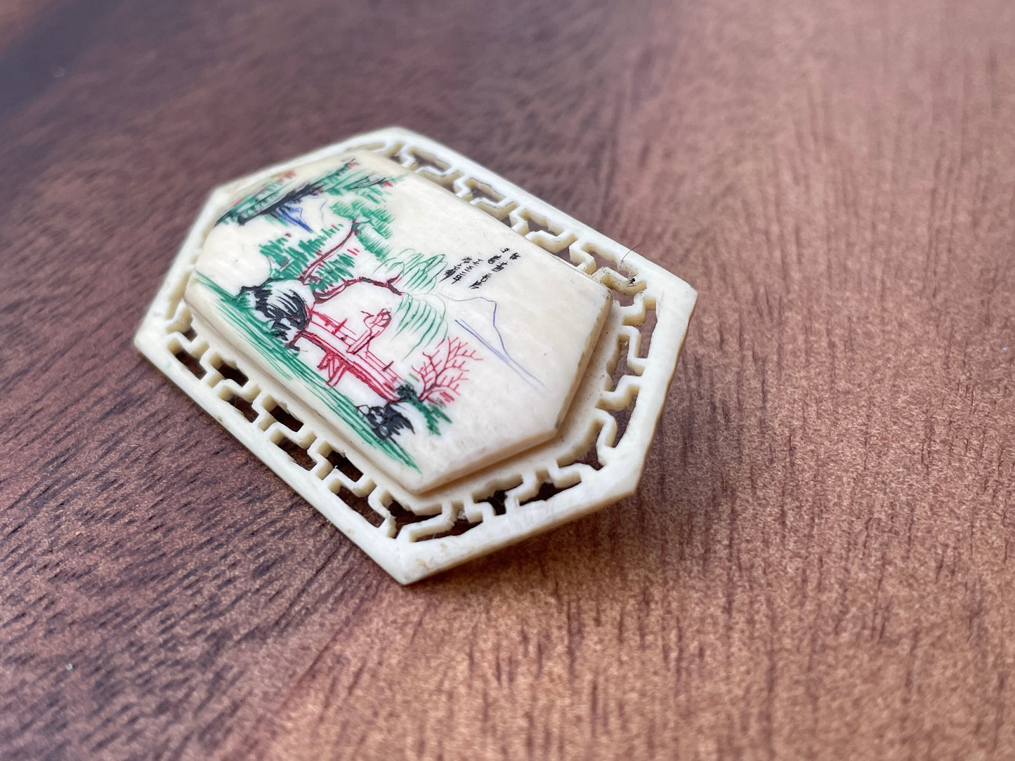 A Small Chinese Brooch With Hand Etched and Coloured Scene 5cm Wide