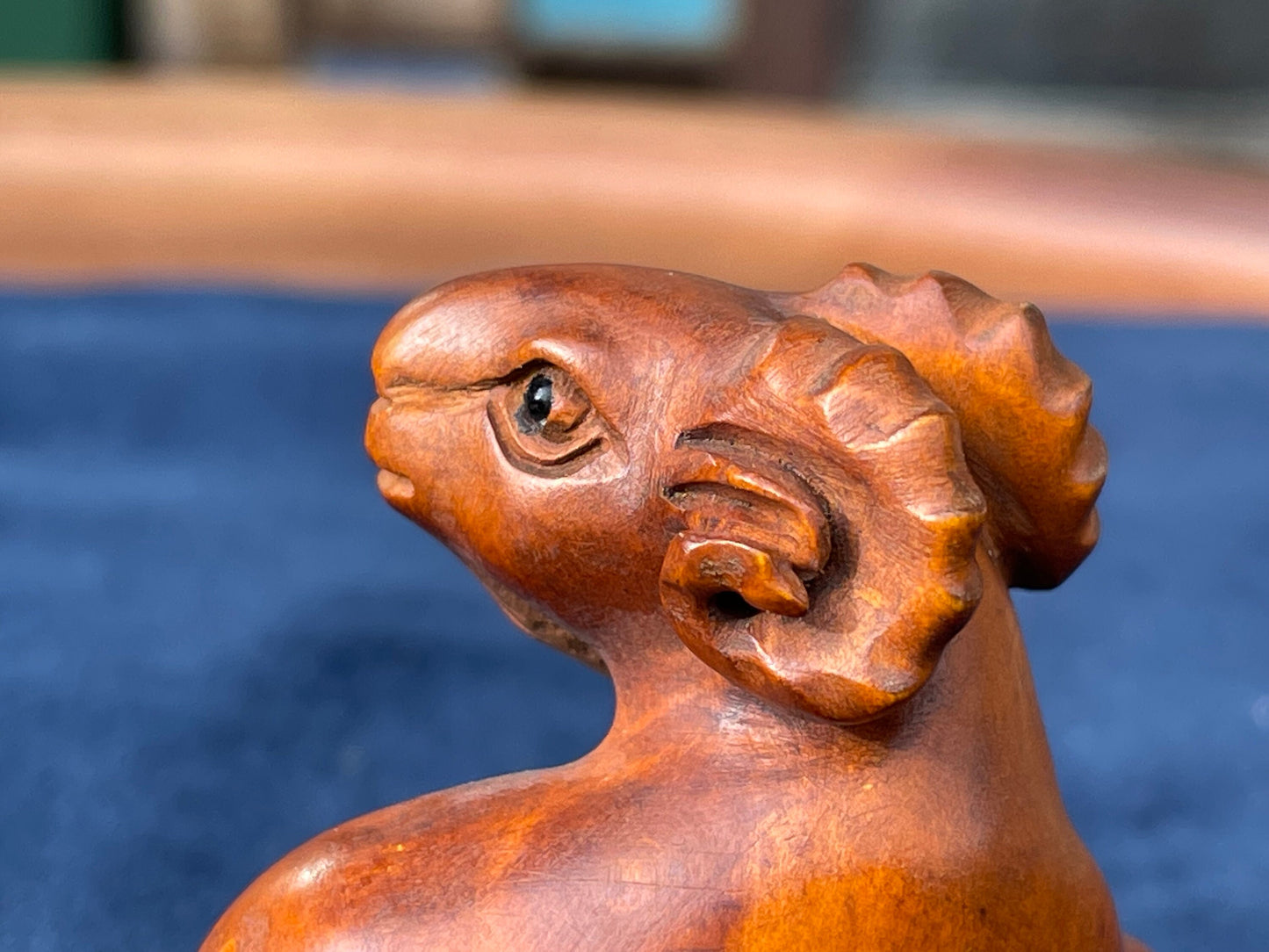 A Japanese hardwood hand carved Ram netsuke with glass eyes 5cm tall