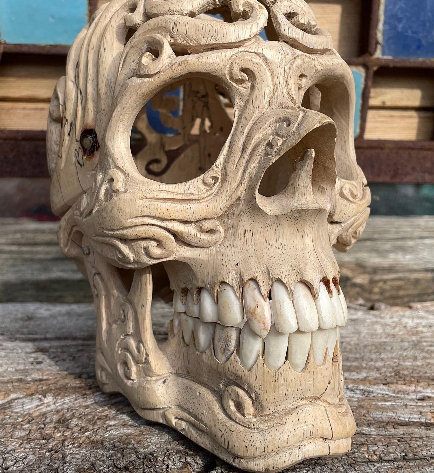 An intricately hand carved Folk Art Skull sculpture from Tamarind wood and buffalo jaw 17cm tall