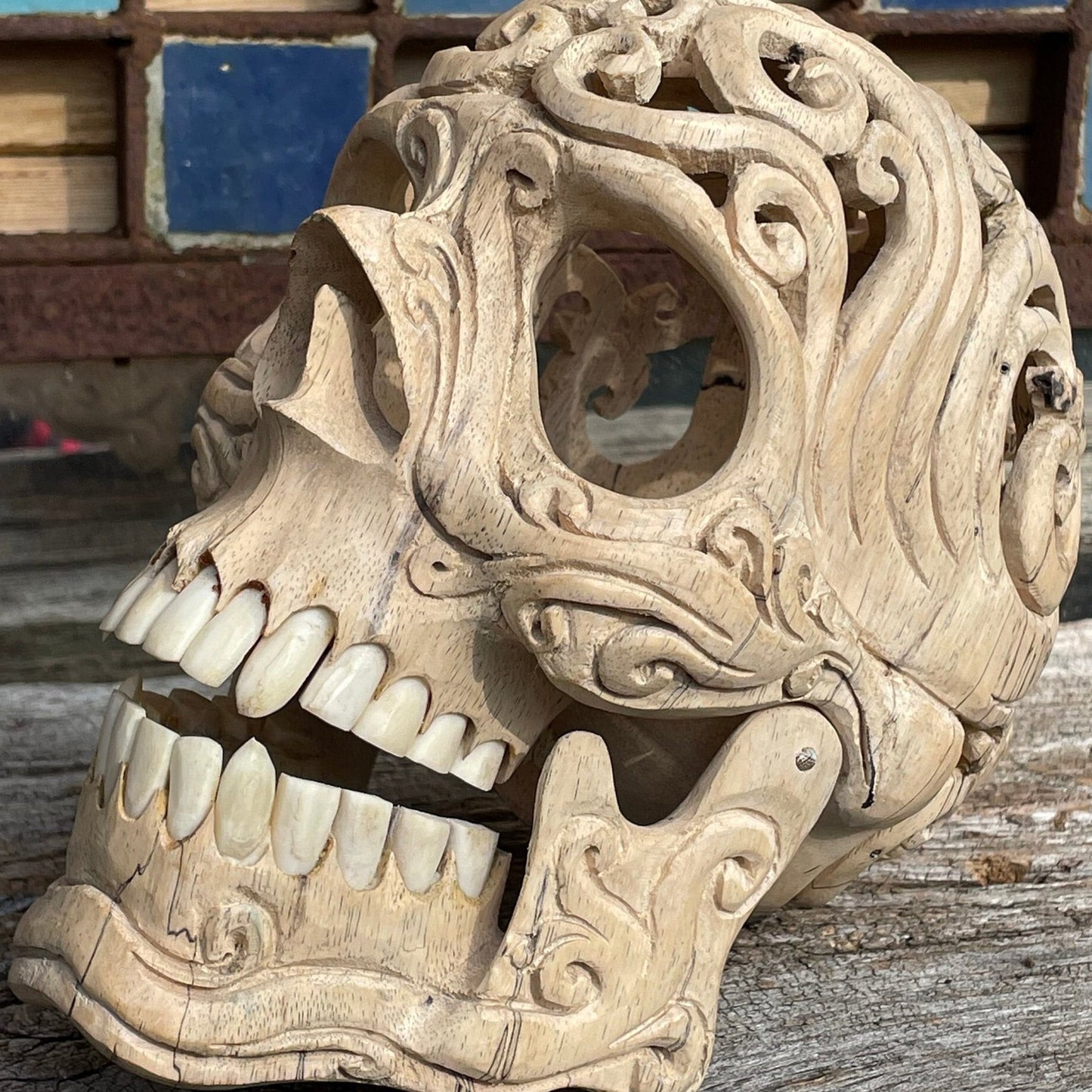 An intricately hand carved Folk Art Skull sculpture from Tamarind wood and buffalo jaw 17cm tall