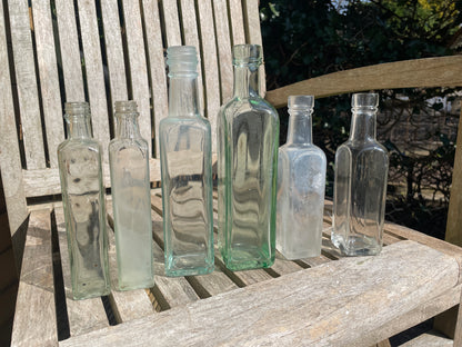 Six antique and vintage clear glass square section bottles tallest 21.5cm