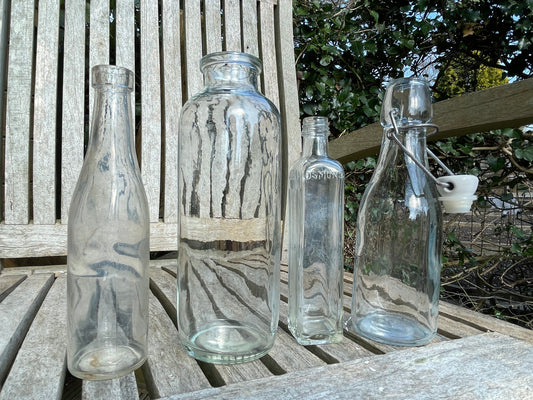 Four vintage clear glass bottles Tallest 19cm