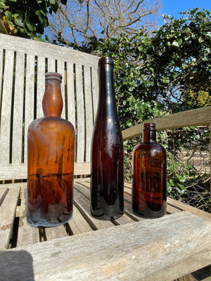 Three Vintage brown glass bottles tallest 29cm