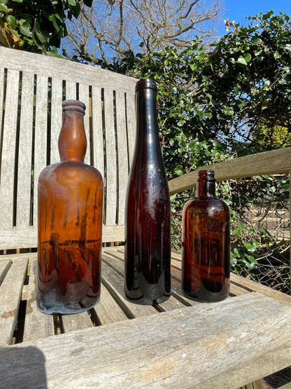 Three Vintage brown glass bottles tallest 29cm