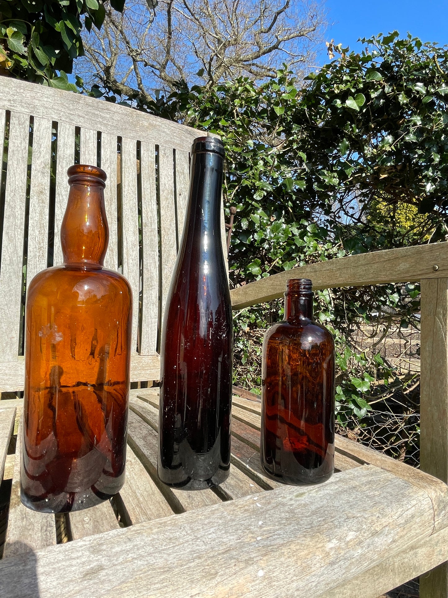 Three Vintage brown glass bottles tallest 29cm