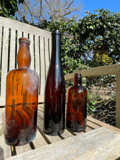 Three Vintage brown glass bottles tallest 29cm