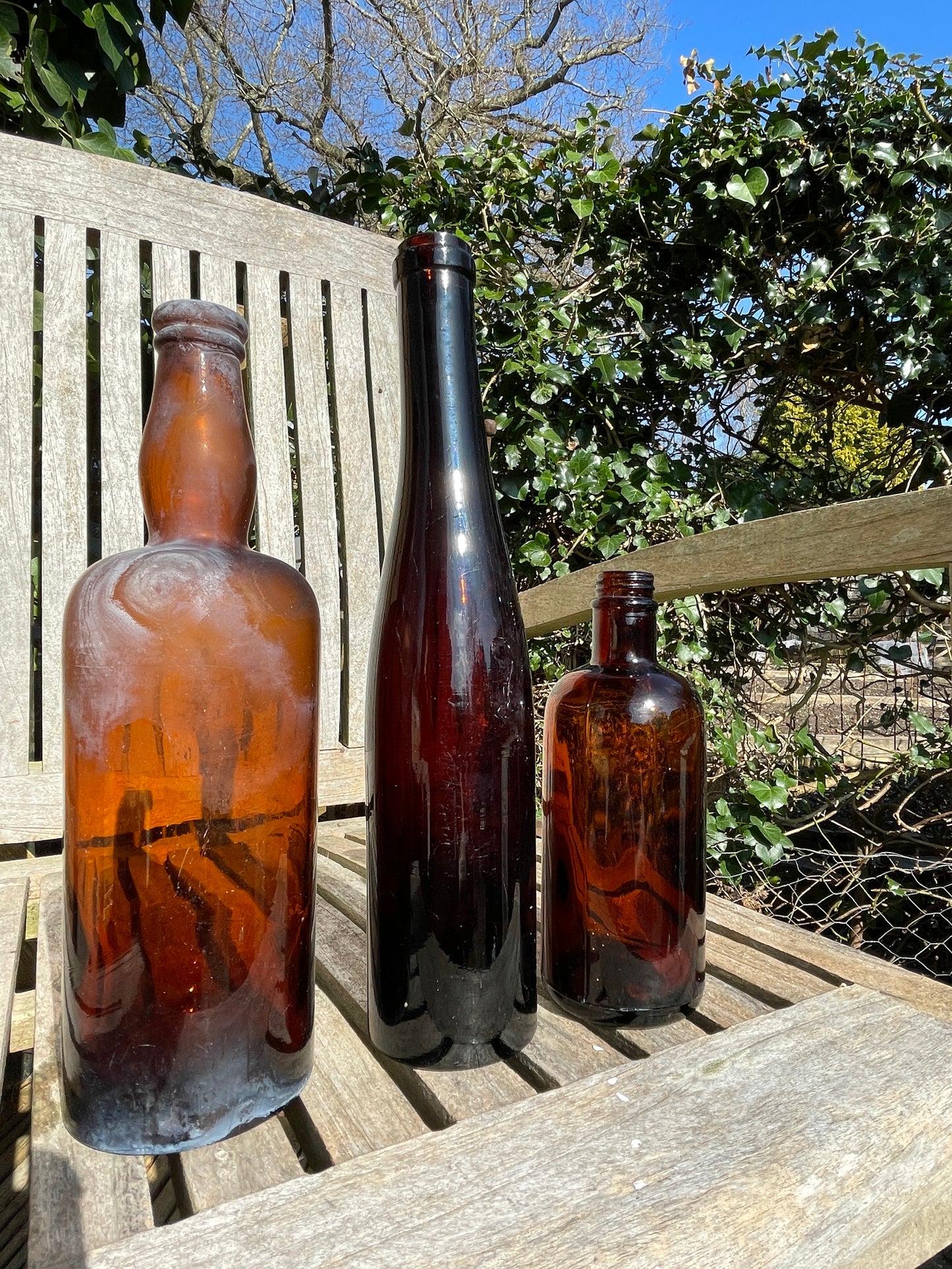 Three Vintage brown glass bottles tallest 29cm
