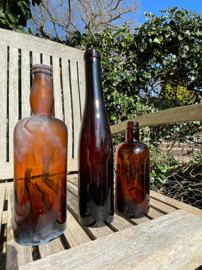 Three Vintage brown glass bottles tallest 29cm