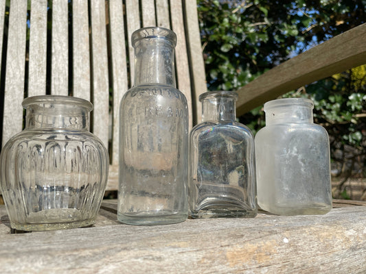 Four clear glass vintage bottles tallest 13.5cm one marked Furniture cream Stephenson Brothers