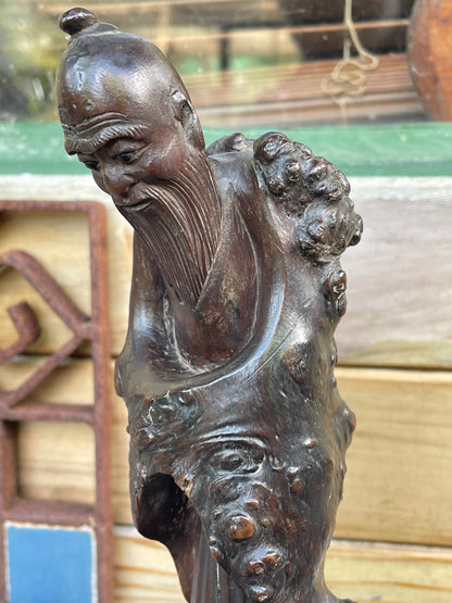 A Chinese Root Wood Hand Carving of an Elder Raised on a Later Oval Ebony Base, Overall 23.5cm High