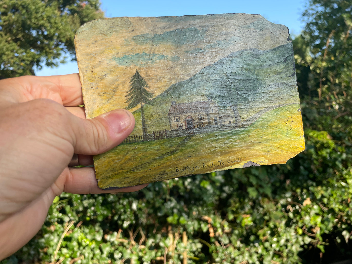 Hand painted unique folk art painting of a Welsh cottage inscribed 'Bwthyn Bach to Gwelt' on slate