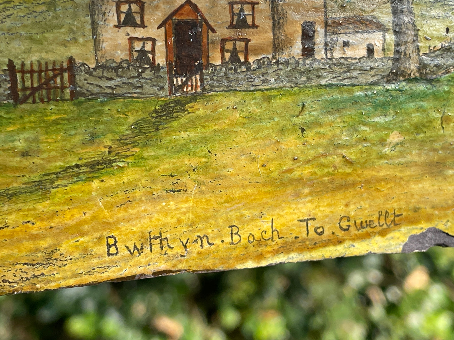 Hand painted unique folk art painting of a Welsh cottage inscribed 'Bwthyn Bach to Gwelt' on slate