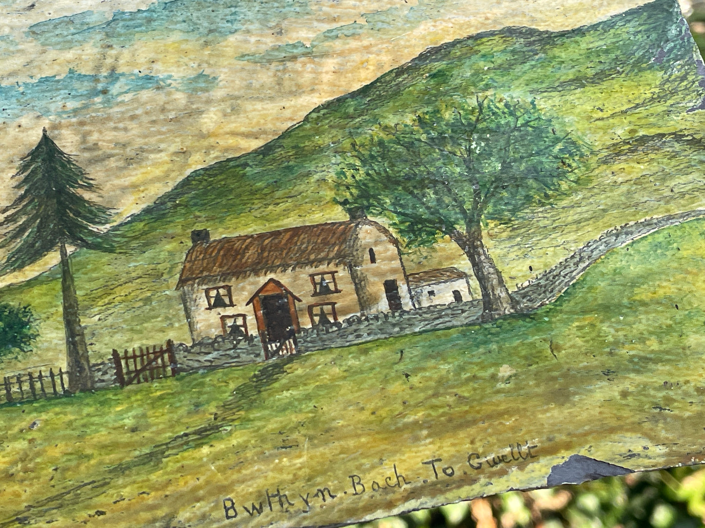 Hand painted unique folk art painting of a Welsh cottage inscribed 'Bwthyn Bach to Gwelt' on slate