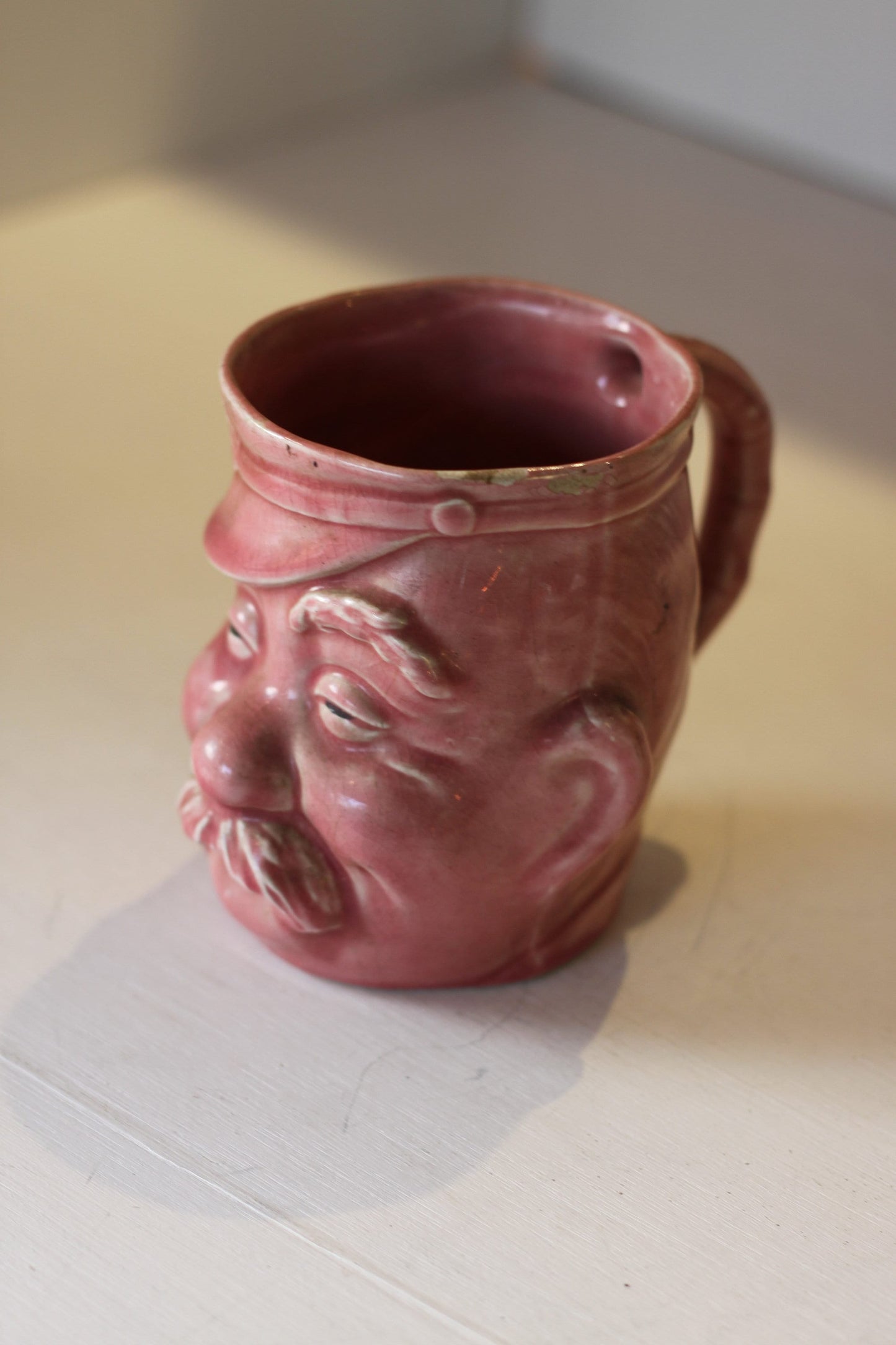 A Vintage Dusky Pink Glazed Military Mug in The Form of Bruce Bairnsfather's Old Bill, 11.5cm high