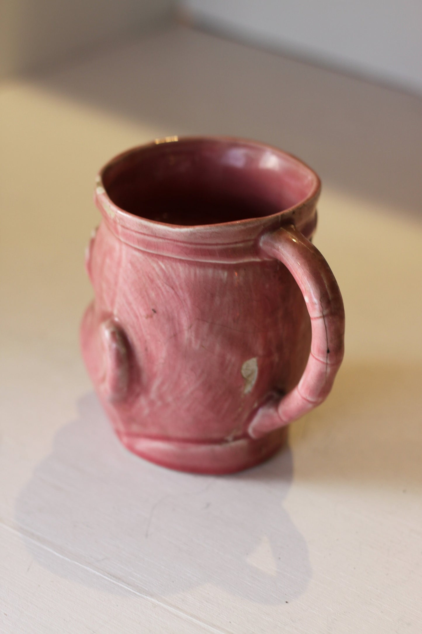 A Vintage Dusky Pink Glazed Military Mug in The Form of Bruce Bairnsfather's Old Bill, 11.5cm high