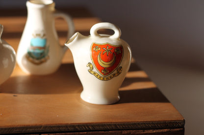 Two W.H Goss Crest ware, Lampeter Jug, Gloucester Ancient Pitcher and an Arcadian Wareham pitcher