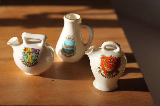 Two W.H Goss Crest ware, Lampeter Jug, Gloucester Ancient Pitcher and an Arcadian Wareham pitcher