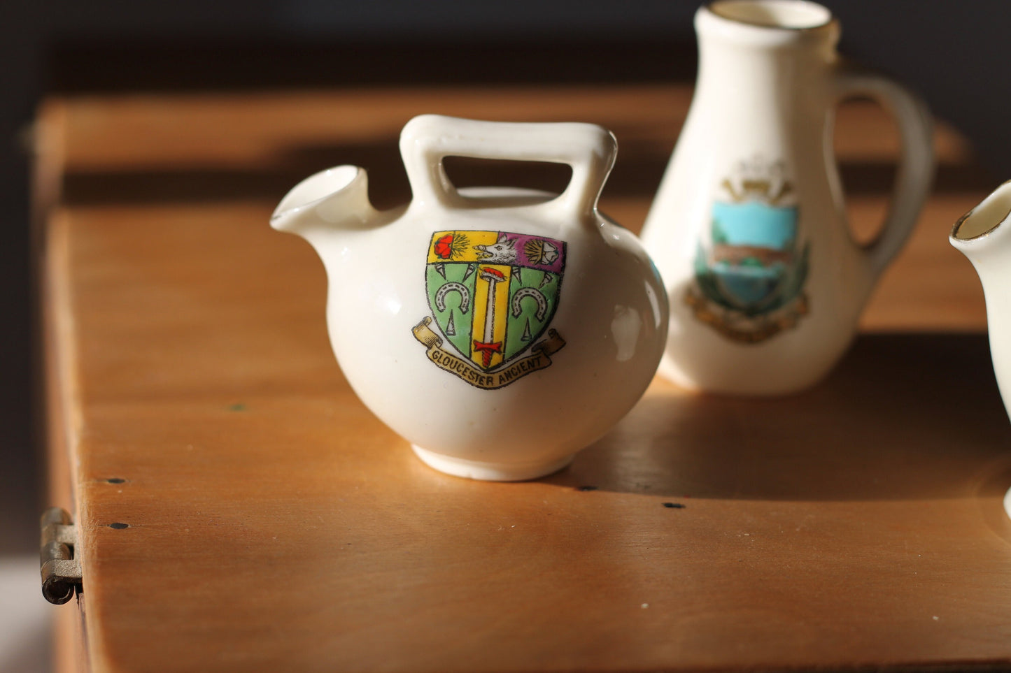 Two W.H Goss Crest ware, Lampeter Jug, Gloucester Ancient Pitcher and an Arcadian Wareham pitcher