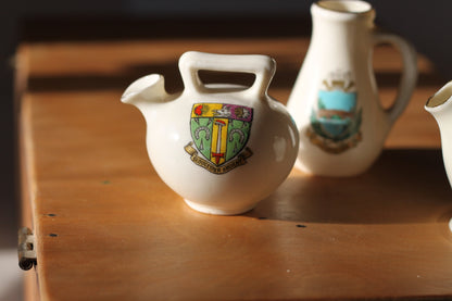 Two W.H Goss Crest ware, Lampeter Jug, Gloucester Ancient Pitcher and an Arcadian Wareham pitcher