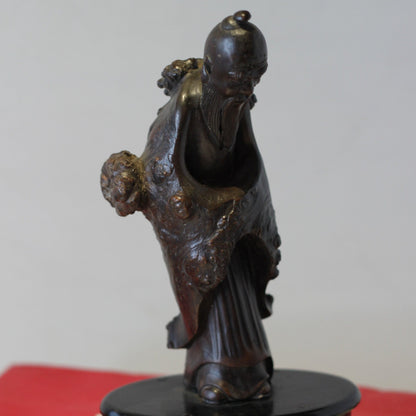 A Chinese Root Wood Hand Carving of an Elder Raised on a Later Oval Ebony Base, Overall 23.5cm High