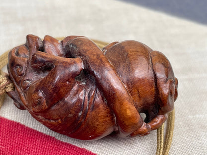 A Hand Carved Wooden Dress Toggle of a Chinese Mythical Beast on a Silk Cord 4.5cm Long